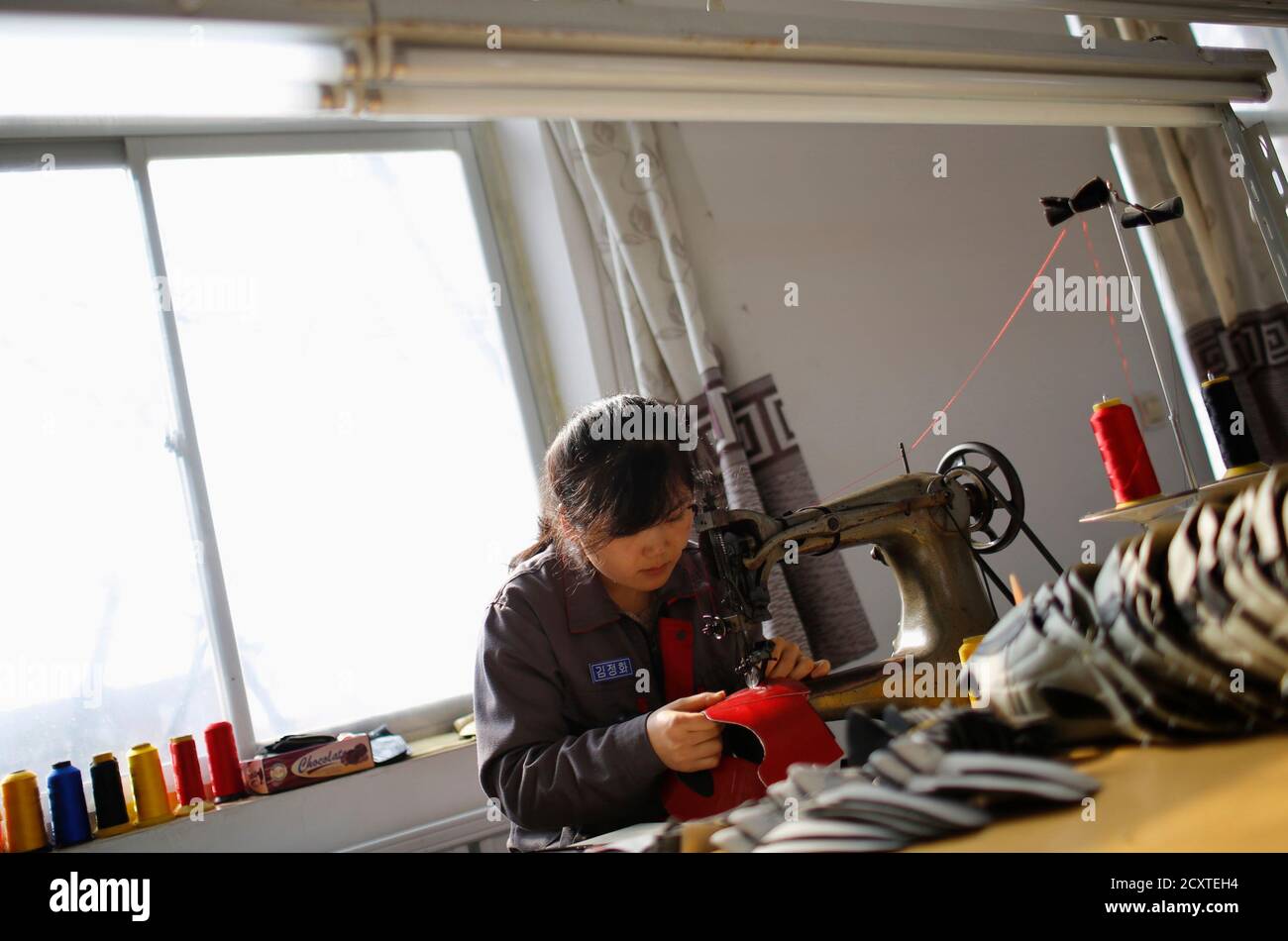 A North Korean worker sews inside a temporary soccer shoe factory at a  rural village on the edge of Dandong October 24, 2012. Top soccer-boot  maker Adidas probably shouldn't be worrying just