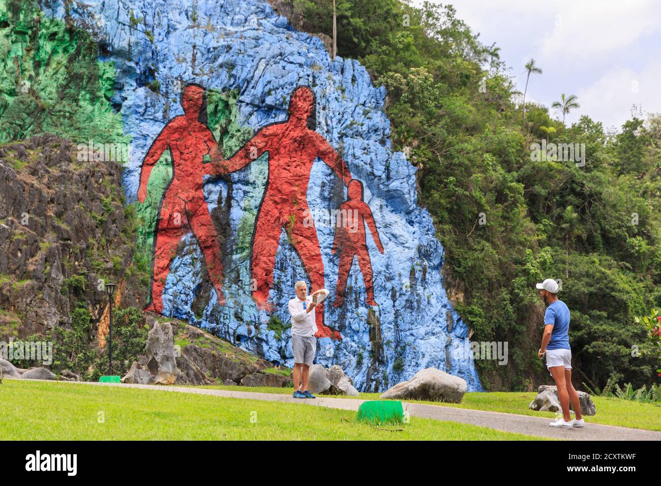 Attraction touristique, les gens prennent des photos avec une reproduction géante de "peinture préhistorique" achevée en 1961 sur le mur de roche, Parque Nacional Viñales, Cuba Banque D'Images