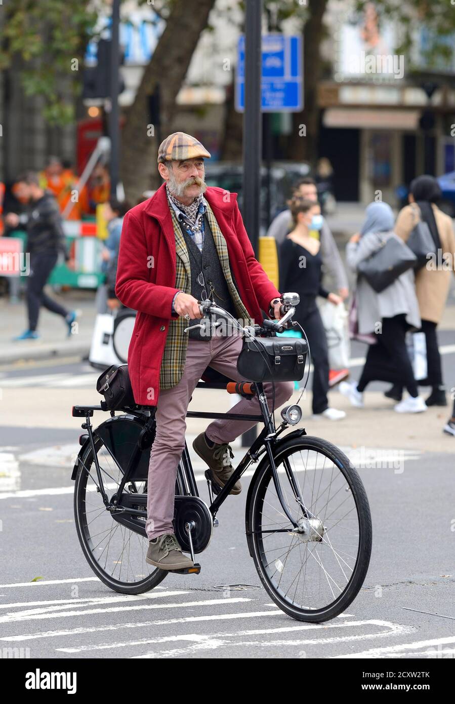 Londres, Angleterre, Royaume-Uni. Homme vêtu de façon intéressante, faisant du vélo dans le Strand Banque D'Images