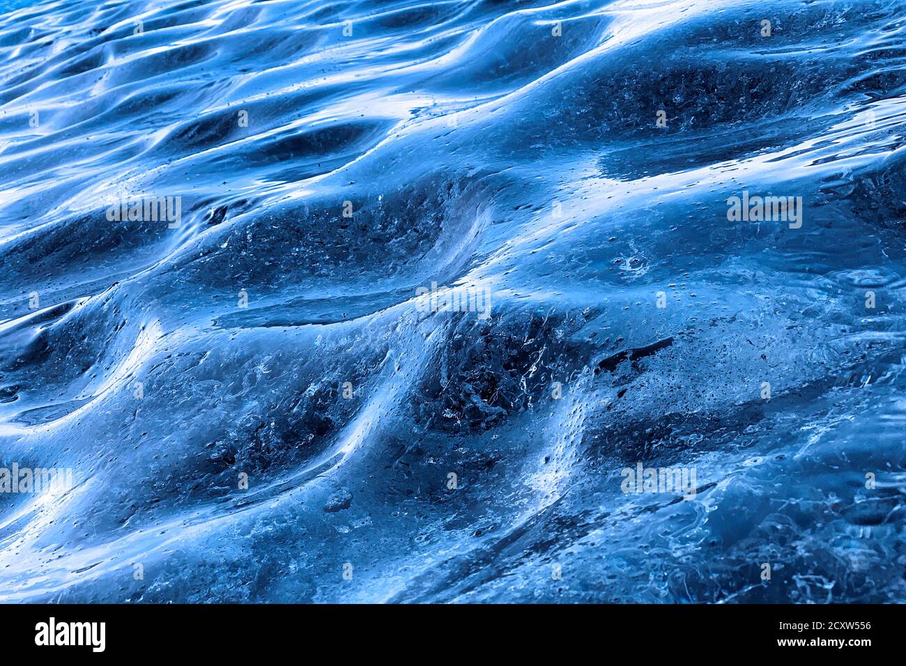 Gros plan de la glace bleue glaciaire. Fond de glace bleue formant le mur d'une grotte de glace en Islande. Banque D'Images