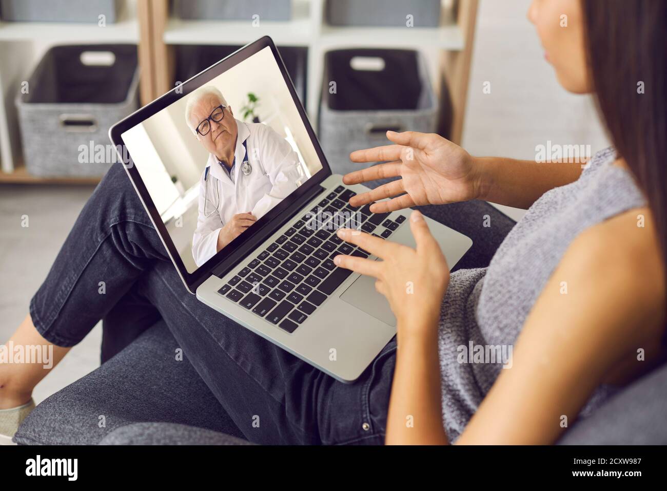 Jeune femme utilisant un ordinateur portable et parlant à un médecin expérimenté lors de la consultation vidéo en ligne Banque D'Images