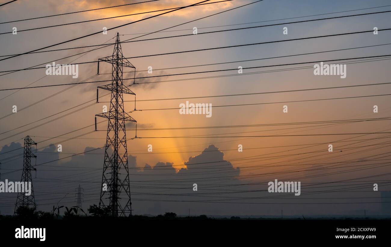 Lignes électriques haute tension à Sunrise/Sunset. Station de distribution d'électricité.Saltpans à Mumbai. Banque D'Images