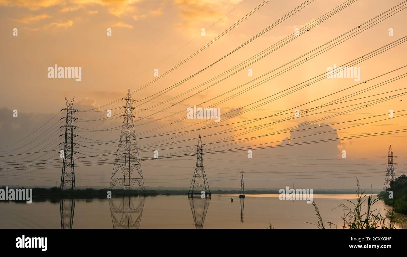 Lignes électriques haute tension à Sunrise/Sunset. Station de distribution d'électricité.Saltpans à Mumbai. Banque D'Images