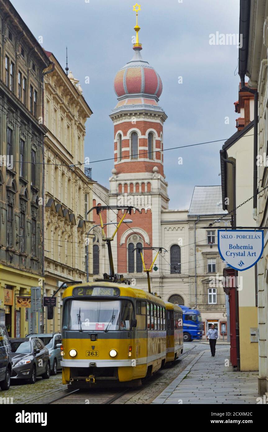 Un tram sur l'étroite vieille rue du centre de Plzen avec la grande synagogue en arrière-plan Banque D'Images