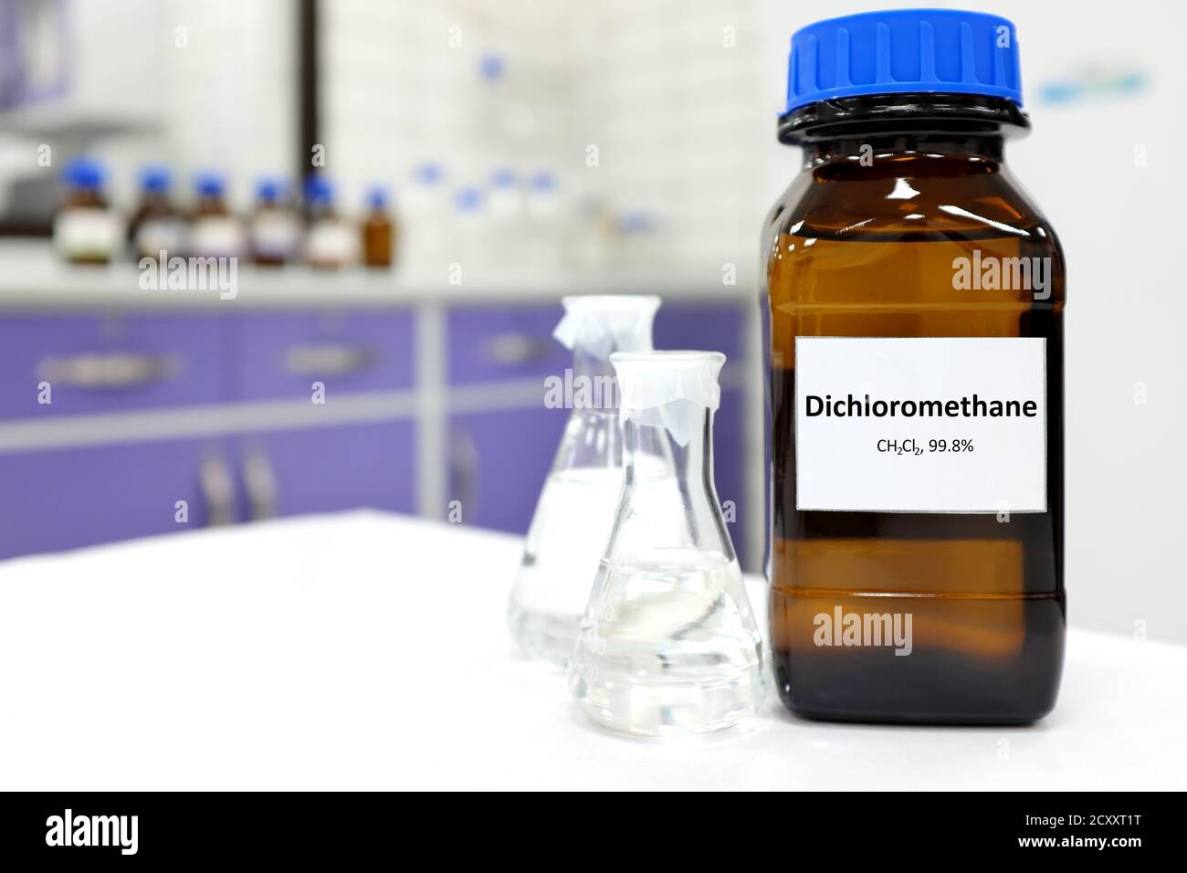 Concentration sélective du composé chimique liquide de dichlorométhane dans un flacon en verre foncé à l'intérieur d'un laboratoire de chimie avec un espace de copie. Banque D'Images