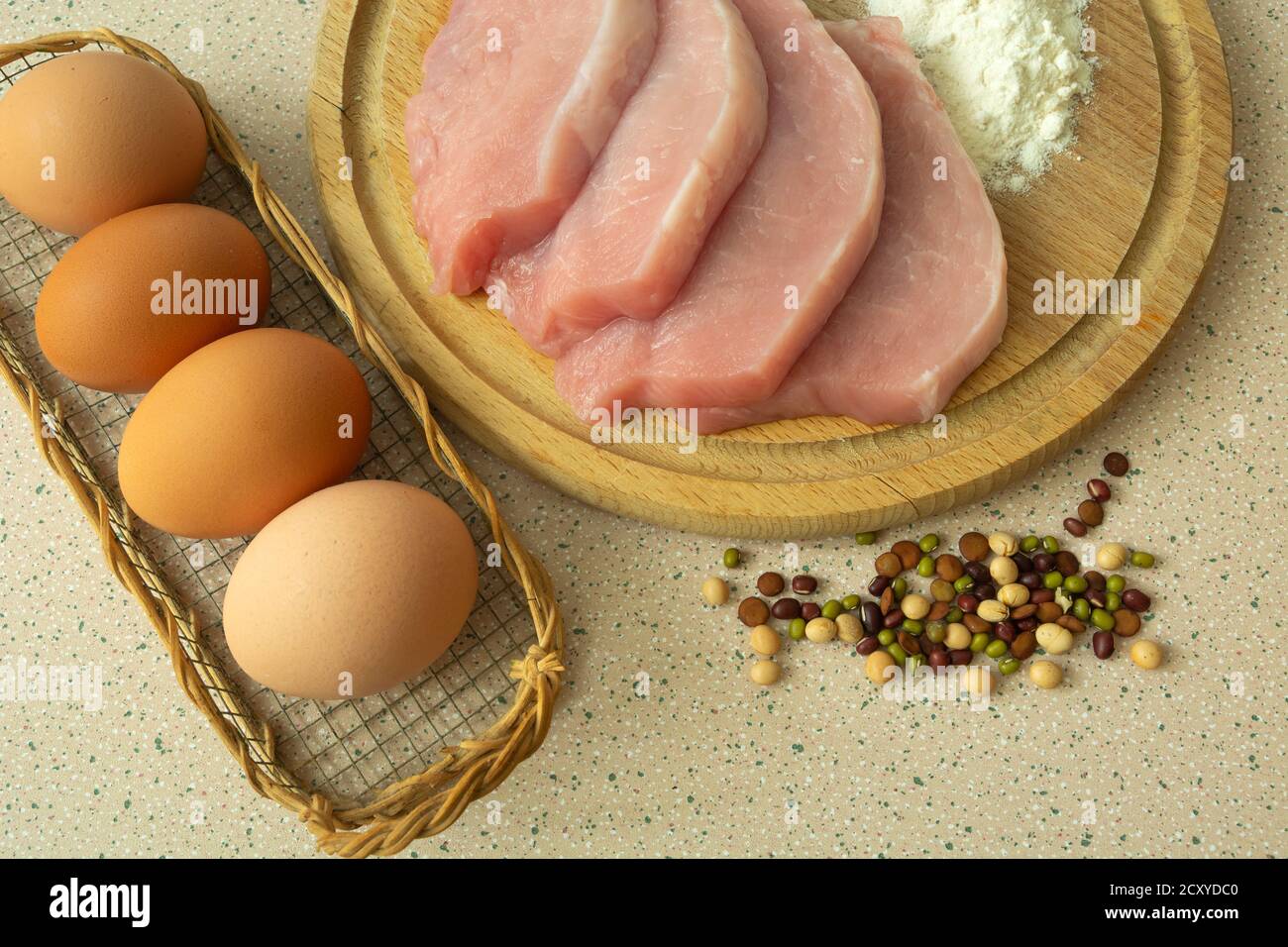 Filet de porc sur une planche, farine blanche, œufs et épices Banque D'Images