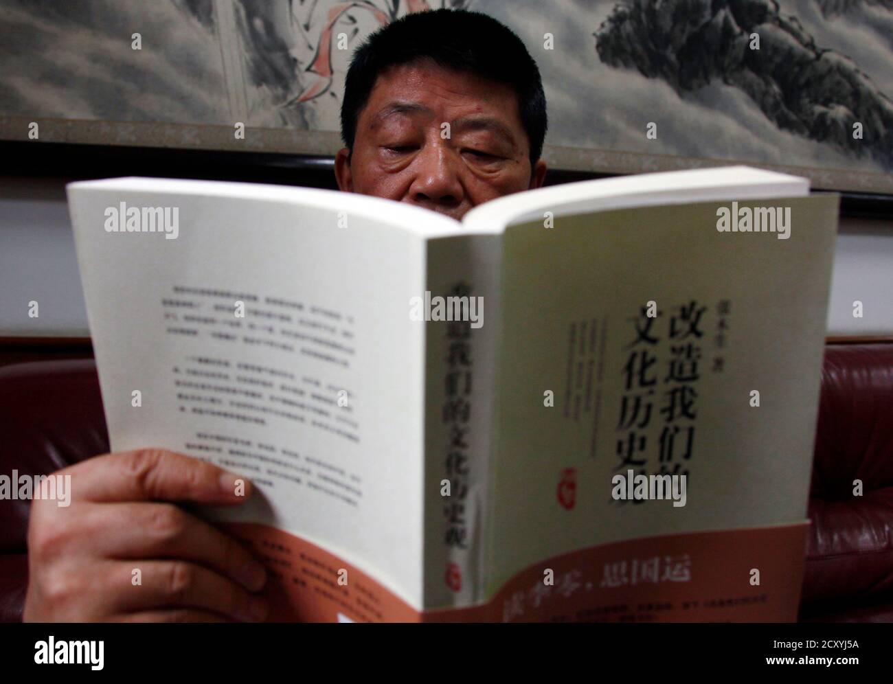 Retired Chinese Official And Author Zhang Musheng Poses For A Photograph  With His New Book 