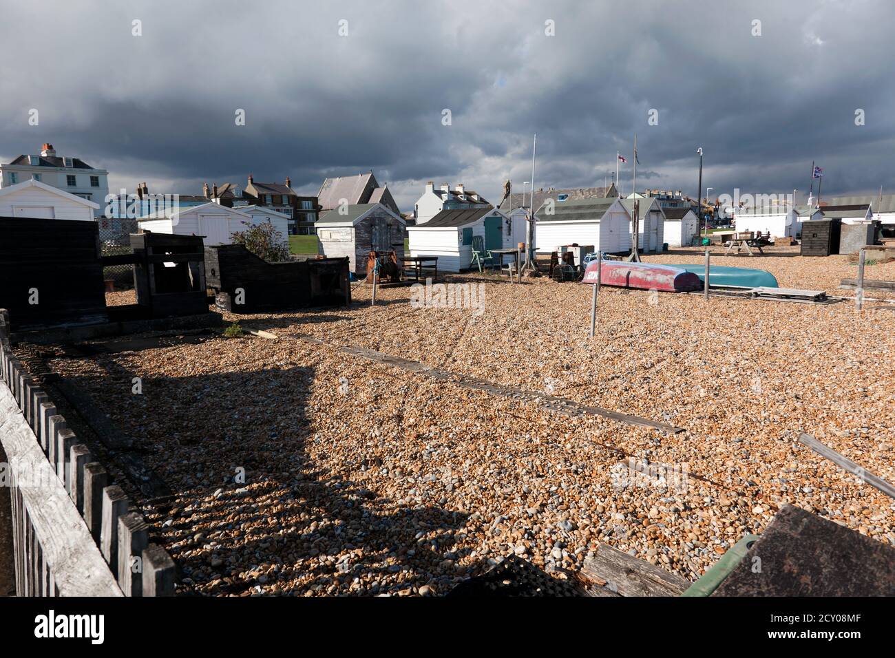 Un groupe de cabanes de pêcheurs sur Walmer Beach, illuminé contre un ciel d'abaissement Banque D'Images