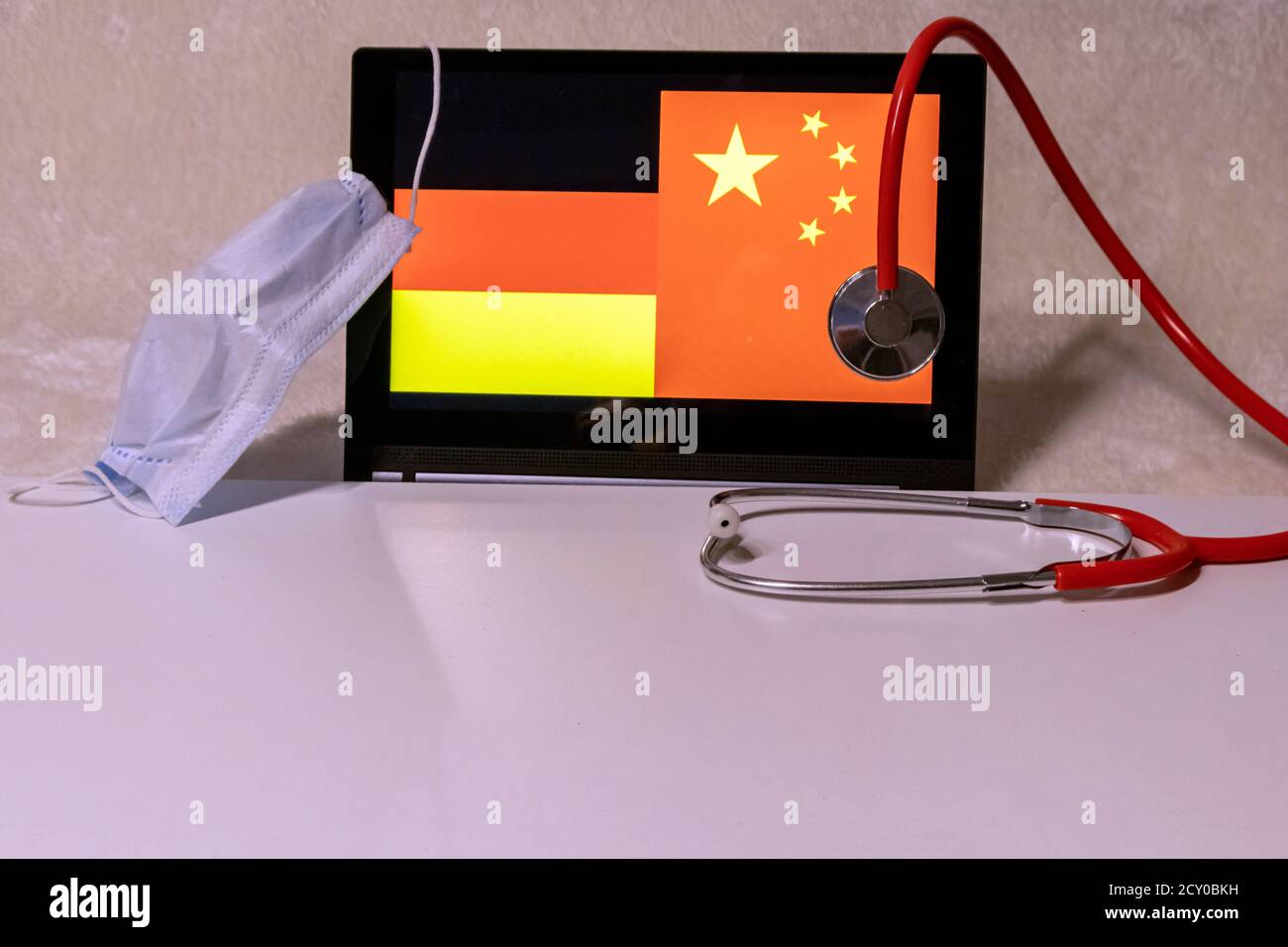 Infection à Corona-virus 2019-nCoV en allemagne en provenance de chine représentée par le drapeau allemand et le drapeau chinois, masque médical comme protection et un stéthoscope Banque D'Images