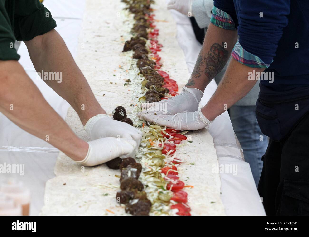 Les participants qui font le plus long shawarma végétarien.record-brisant 27 mètres et 87 cm de long shawarma vegan avec le falafel a été fait à la Journée mondiale végétarienne. Après qu'il a été fait, tout le monde l'a goûté. La Journée mondiale de la végétarienne est célébrée chaque année dans le monde entier le 1er octobre. Banque D'Images