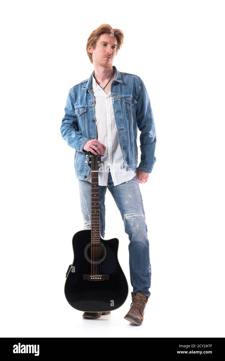 Guitariste homme macho confiant posant avec de la guitare en Jean. Corps entier isolé sur fond blanc. Banque D'Images