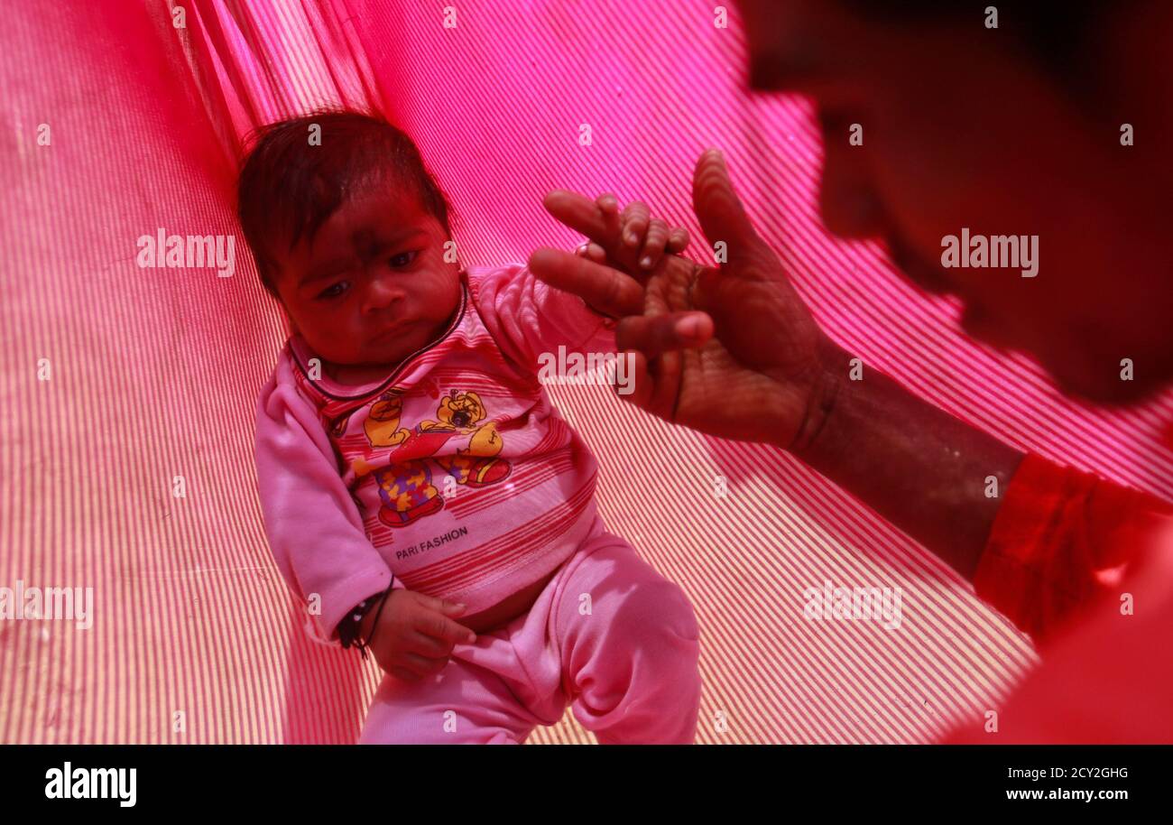 Gopal Kishan 16 Plays With His Four Month Old Baby Alok While Sitting Outside His Wife S House Near Baran Located In The Northwestern State Of Rajasthan January 21 13 Gopal Was Married To His