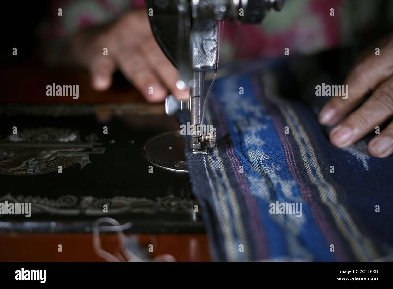 Gros plan femme mains travaillant sur le tapis de prière traditionnel avec ancienne machine à coudre Banque D'Images