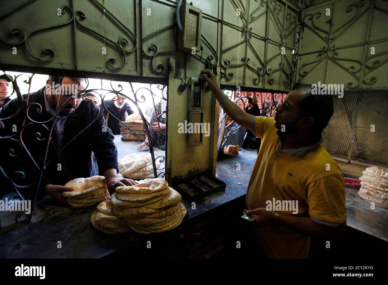 People Queue For Subsidised Bread As A Bakery Worker Looks At A Smart Card Reader In The Suez Canal City Of Port Said 170 Km 106 Miles Northeast Of Cairo February 24