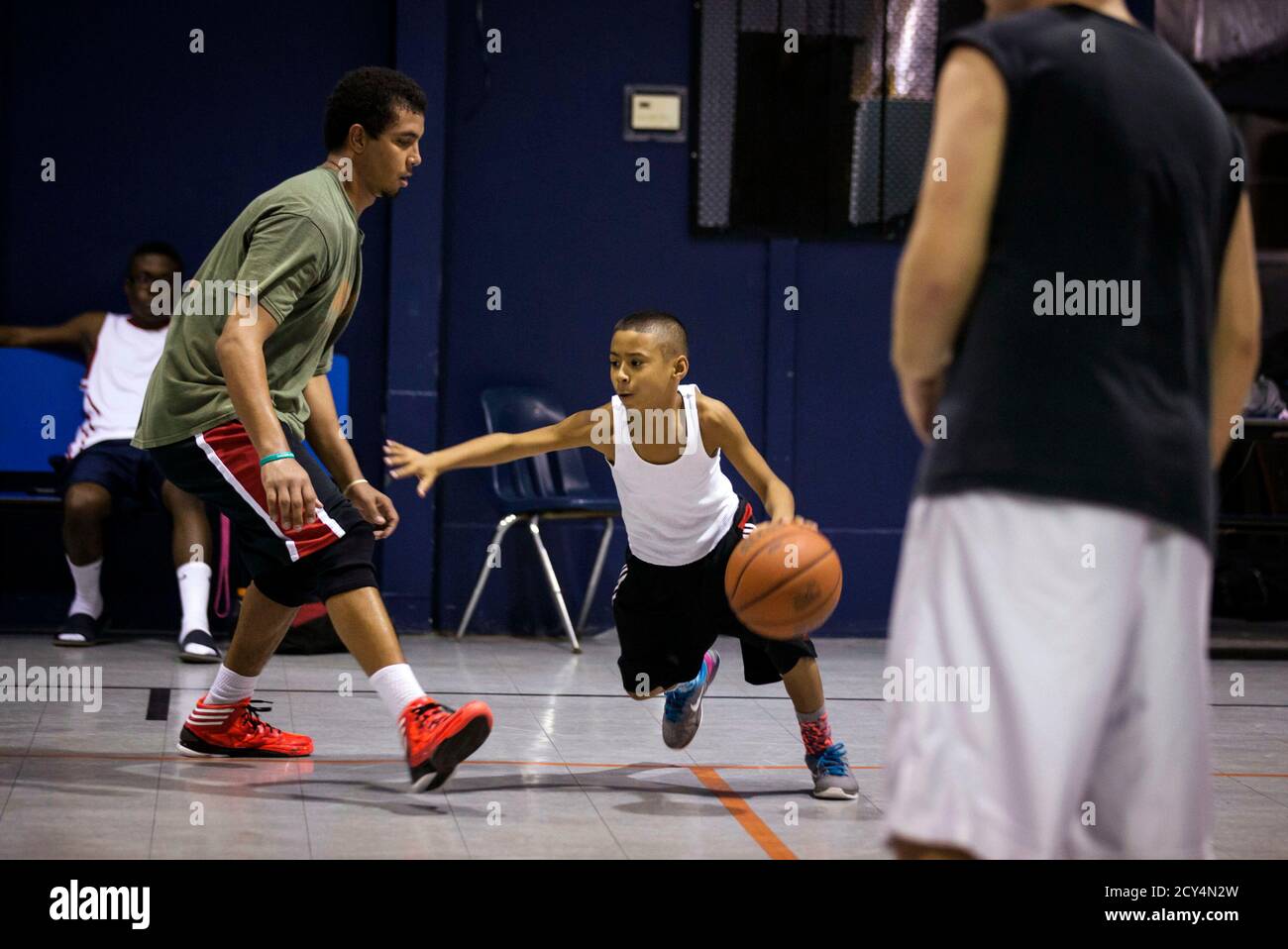 Downey Christian high school varsity basketball player 11-year-old Julian  Newman (L) talks with an older players during Friday evening pickup  basketball games at Downey Christian School in Orlando, Florida February  22, 2013.