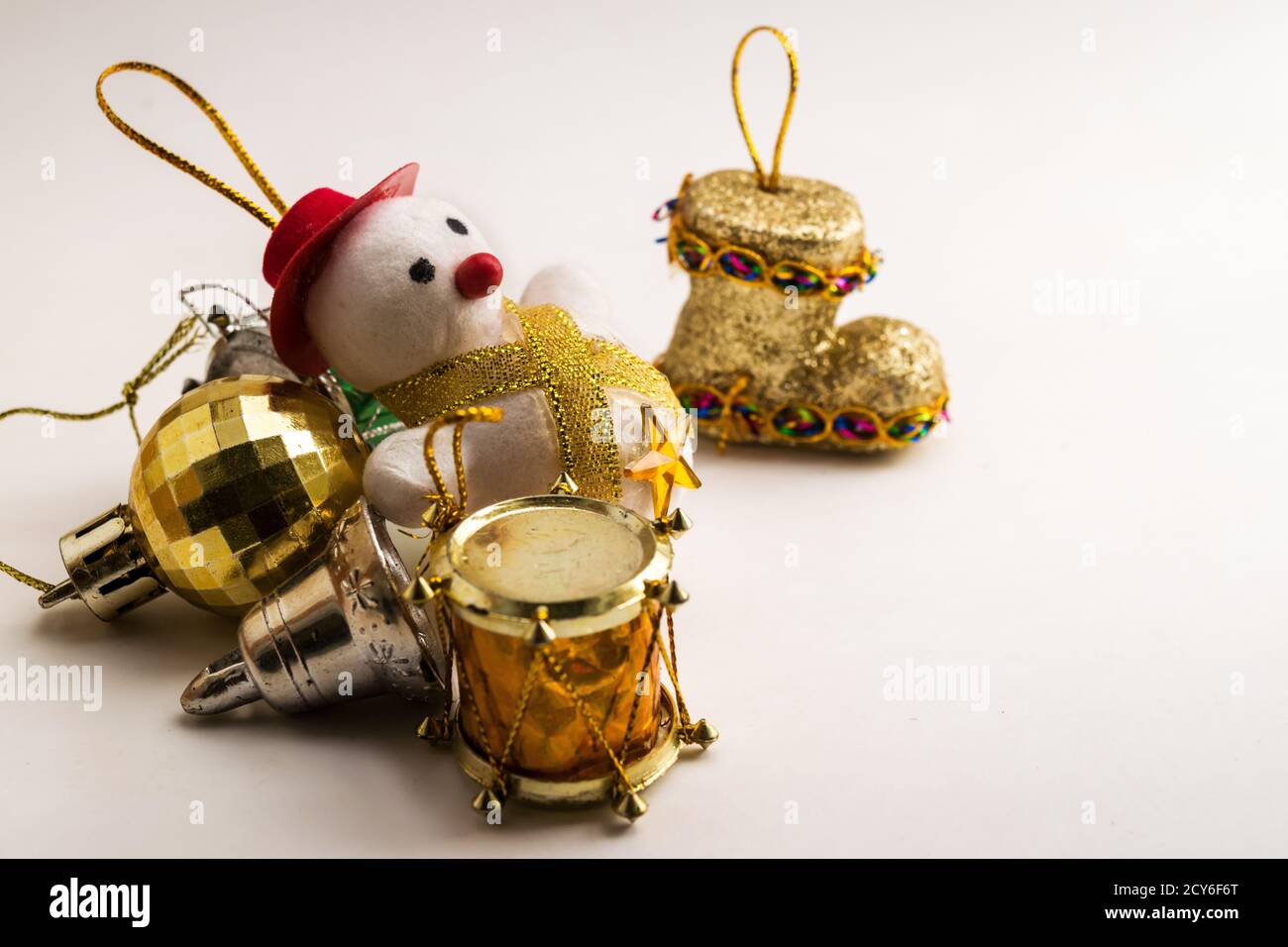 Quelques pièces de décoration de Noël contre une surface blanche, située à gauche de l'image, les couleurs dorées se distinguent. Banque D'Images