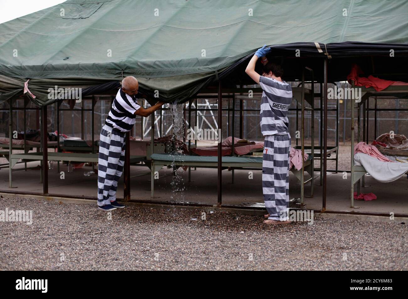 Inmates serving time at Maricopa County's Tent City jail remove water from  a tent in Phoenix, Arizona August 22, 2012. The controversial jail is run  by Maricopa County Sheriff Joe Arpaio, who