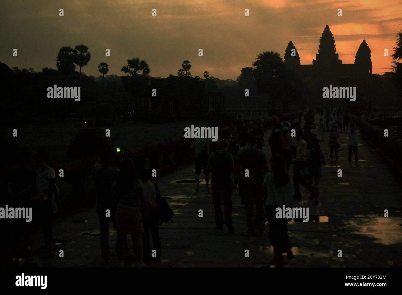 Les foules se déplacent et prennent des photos sur une voie vers Angkor Wat, tôt le matin pour profiter des scènes malgré son ciel sombre au-dessus de Siem Reap, Cambodge. Banque D'Images