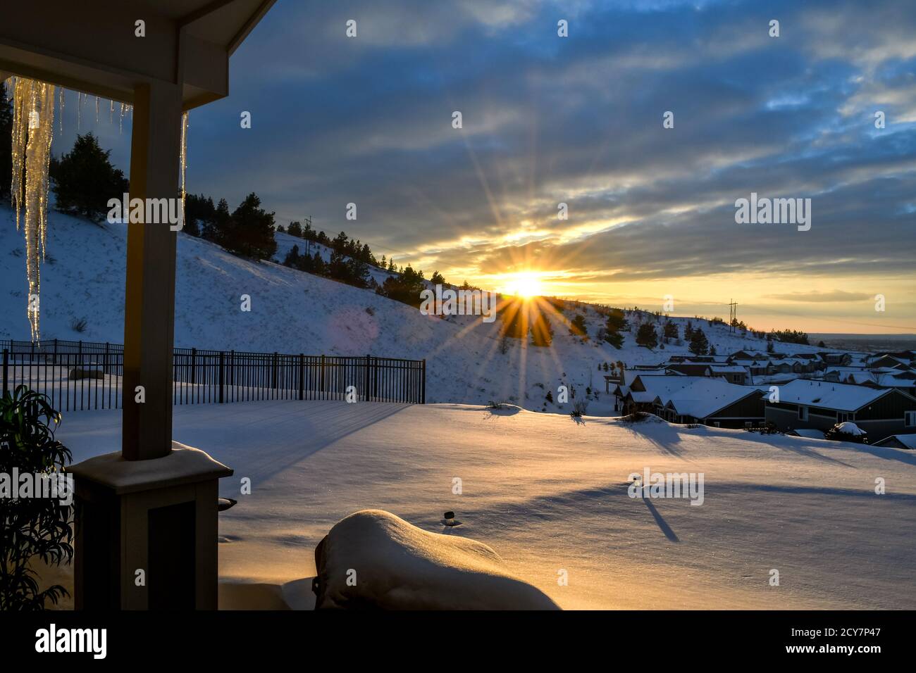 Vue depuis le pont d'une maison tandis que le soleil se couche derrière une colline au-dessus d'une subdivision de maisons pendant la neige et l'hiver à Spokane, Washington, États-Unis Banque D'Images