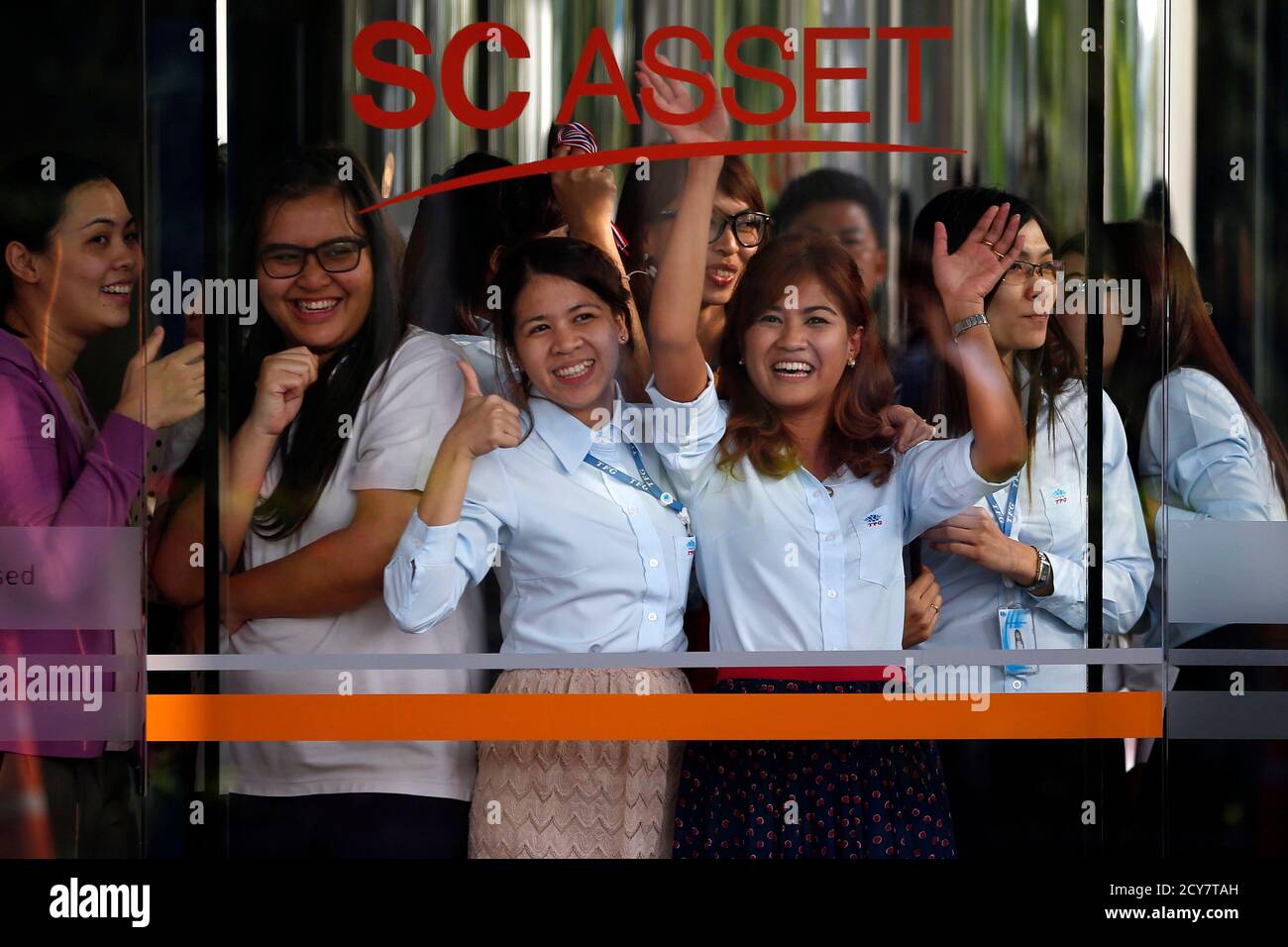 Les femmes regardent et branle depuis l'intérieur d'un bâtiment d'affaires appartenant à SC Asset Corp, alors que des manifestants antigouvernementaux se sont rassemblés à l'extérieur, à Bangkok le 19 février 2014. Mercredi, après que le chef des manifestants anti-gouvernement à Bangkok ait déclaré qu'ils cibleraient des actifs liés à la famille du Premier ministre Yingluck Shinawatra, les actions du promoteur immobilier thaïlandais SC Asset Corp ont chuté de plus de 4 pour cent à un niveau de six jours. La famille Shinawatra possède environ 60 % de SC Asset, selon le site Web de la société. REUTERS/Damir Sagolj (THAÏLANDE - Tags: POLITIQUE AGITATION CIVILE AFFAIRES) Banque D'Images