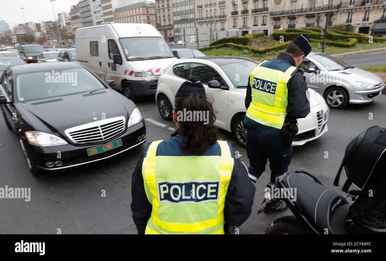 Police officers control cars with even-numbered licence plates which are  not allowed to drive today, at Porte Maillot in Paris March 17, 2014. France  deployed hundreds of police in Paris on Monday