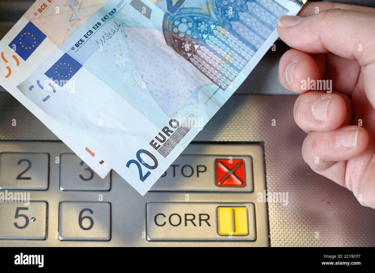 A woman holds a 20 and 50 Euro bank notes in front of an ATM in this  illustration picture taken in Bern January 16, 2015. German bond yields hit  record lows on