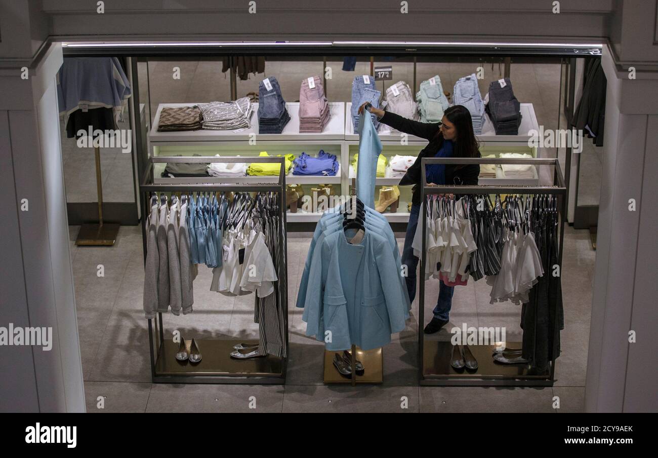 A woman looks at clothes inside a Zara store in central Madrid March 18,  2014. Inditex, the world's biggest fashion retailer, will accelerate  investment in 2014 to open more new stores after