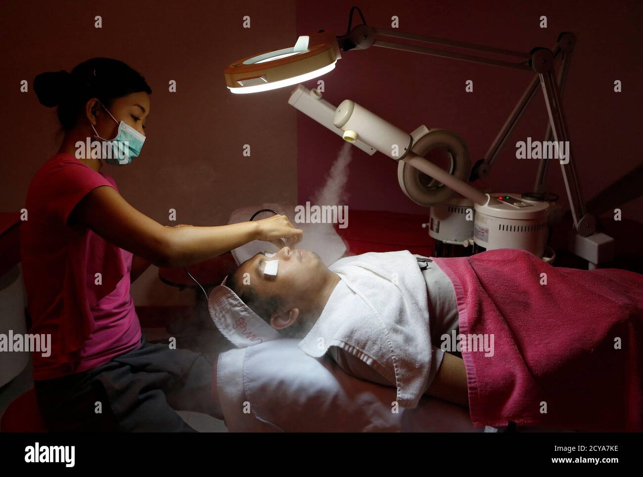 Une esthéticienne traite le visage d'un client masculin lors d'un  traitement du visage, qui coûte 21 $ (880 pesos), dans une clinique de  soins de la peau dans un centre commercial de