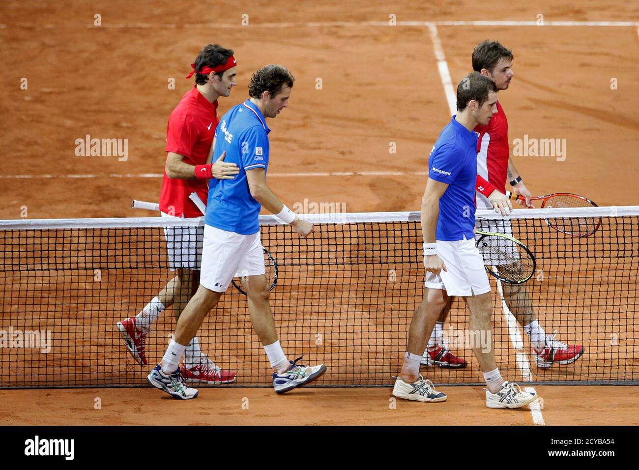 Switzerland's Roger Federer (L) and team mate Stanislas Wawrinka (R) speak  with France's Julien Benneteau (2ndL) and Richard Gasquet (2ndR) after  winning their Davis Cup final doubles tennis match at the Pierre-Mauroy