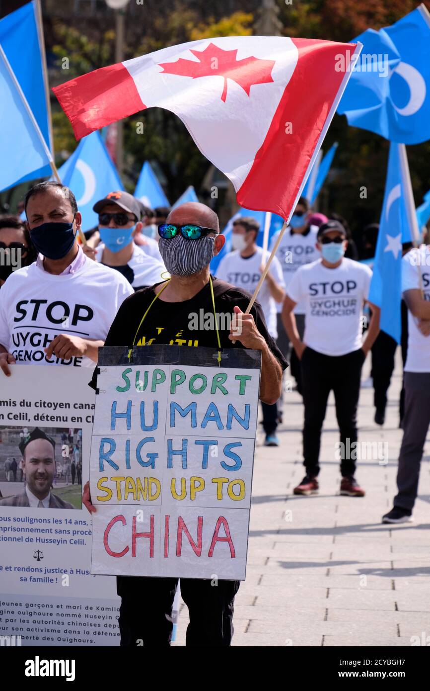 Manifestant au rassemblement d'Uyghur à Ottawa avec le signe 'Support Human Droits Stand up to China' with Canadian flag Banque D'Images