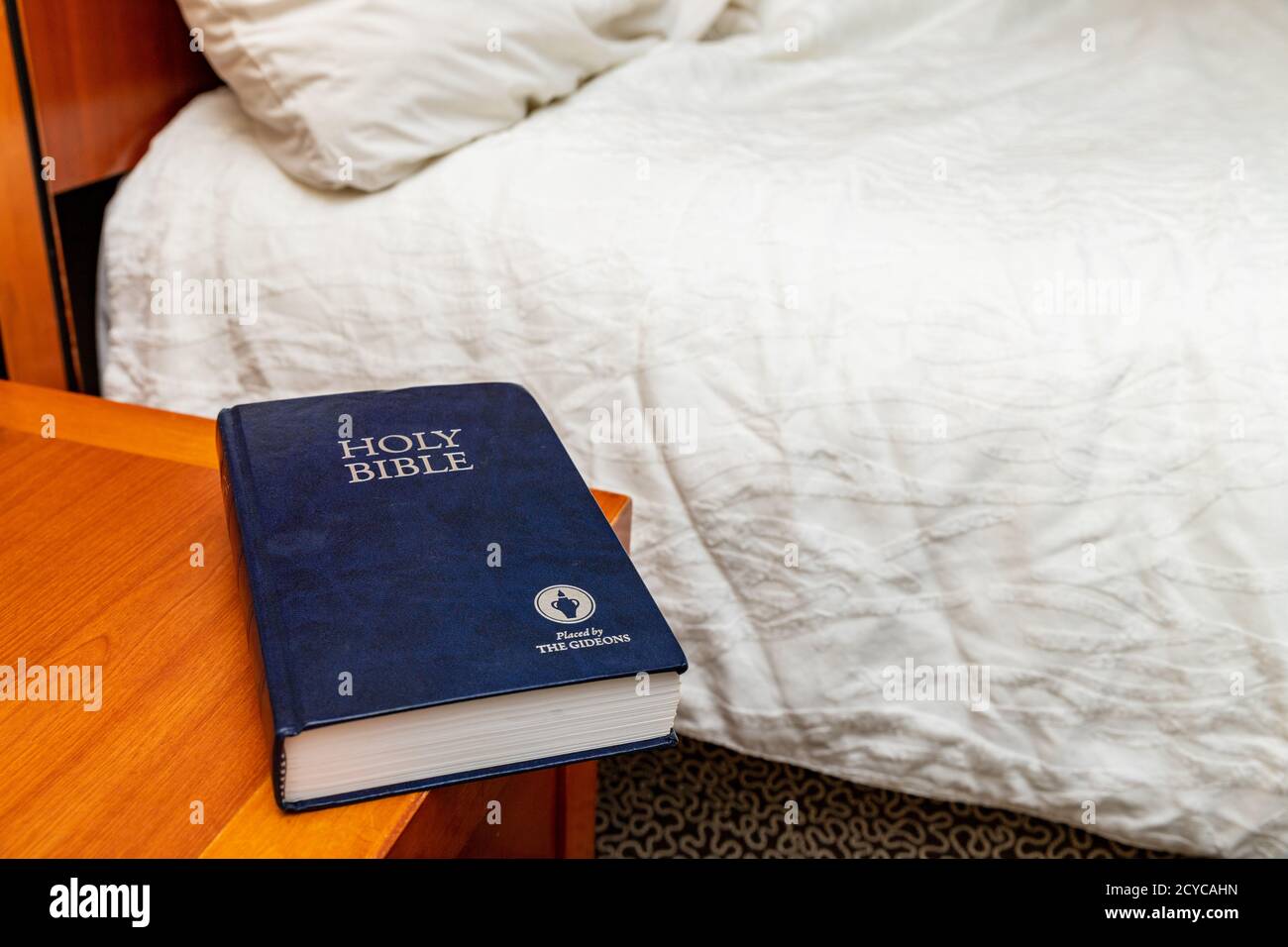 Bible Gideons sur la table de nuit dans la chambre d'hôtel Banque D'Images