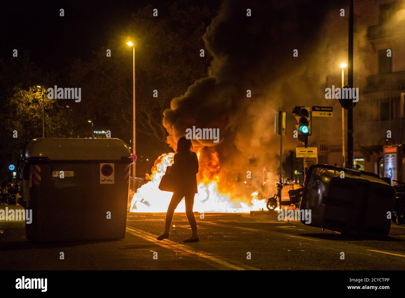 Barcelone, Espagne. 1er octobre 2020. Une femme regarde les récipients en feu. Le troisième anniversaire du 1er octobre 2017, date de la tenue d'un référendum sur l'indépendance pour la Catalogne, banni par le gouvernement espagnol et marqué par l'intervention violente de la police. Des manifestants pro-indépendance ont défilé dans les rues de Barcelone. Crédit : SOPA Images Limited/Alamy Live News Banque D'Images