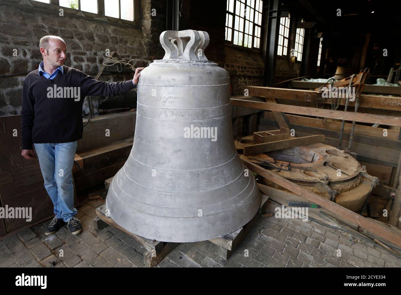 Foundry owner Paul Bergamo looks at the bronze bell 'Denis', one of the