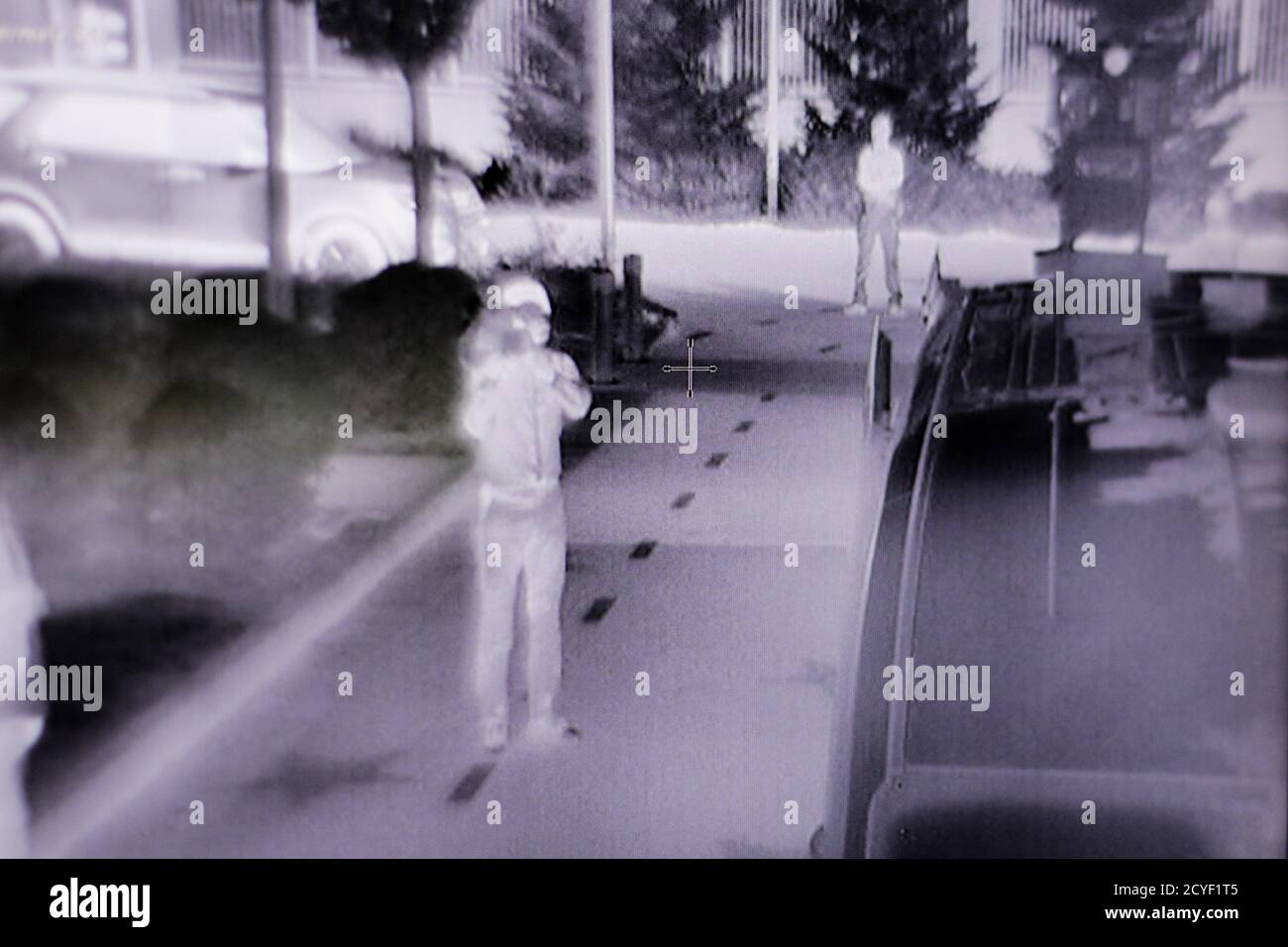 Détails avec des personnes vues sur un moniteur à partir d'une caméra de surveillance infrarouge/thermique. Banque D'Images