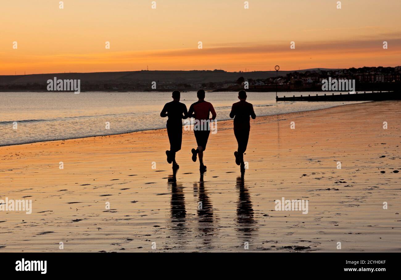 Portobello, Édimbourg, Écosse, Royaume-Uni. 2 octobre 2020. Température à 3 degrés au bord de la mer comme les personnes actives sortent au lever du soleil.photo : trois hommes font du jogging le long de la mer. Banque D'Images Portobello, Édimbourg, Écosse, Royaume-Uni. 2 octobre 2020. Température à 3 degrés au bord de la mer comme les personnes actives sortent au lever du soleil.photo : trois hommes font du jogging le long de la mer. Banque D'Images