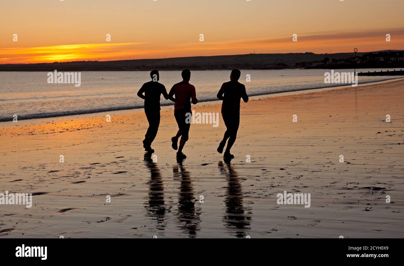Portobello, Édimbourg, Écosse, Royaume-Uni. 2 octobre 2020. Température à 3 degrés au bord de la mer comme les personnes actives sortent au lever du soleil.photo : trois hommes font du jogging le long de la mer. Banque D'Images Portobello, Édimbourg, Écosse, Royaume-Uni. 2 octobre 2020. Température à 3 degrés au bord de la mer comme les personnes actives sortent au lever du soleil.photo : trois hommes font du jogging le long de la mer. Banque D'Images
