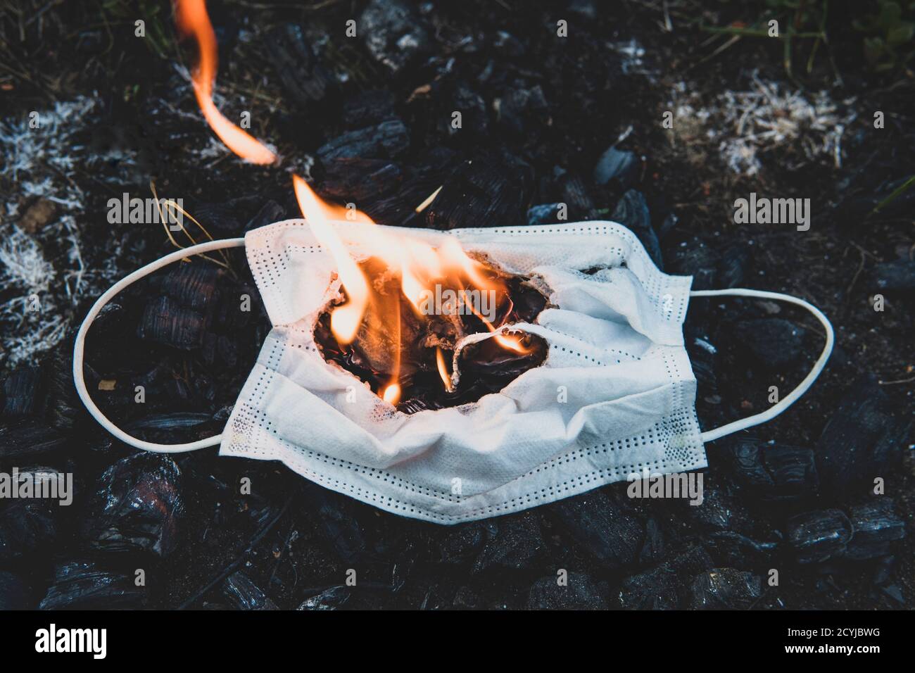 Masque médical brûlant, masque chirurgical avec nettoyage décontaminer le feu. Concept de fin de la pandémie du coronavirus. Incinération destruction de protection Banque D'Images