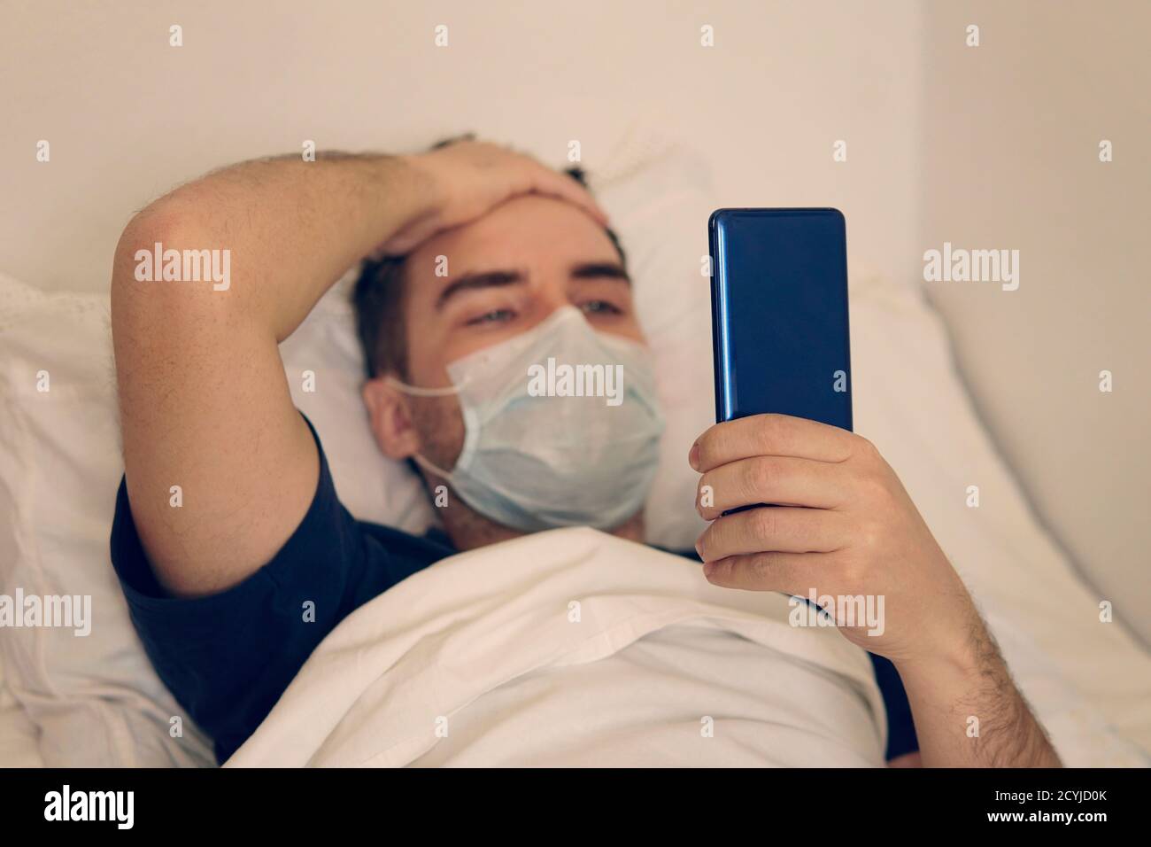 patient ennuyant en utilisant un smartphone pendant qu'il se repose dans le lit d'hôpital. patient malade admis à l'hôpital pour un traitement médical. Réadaptation soins de santé Banque D'Images
