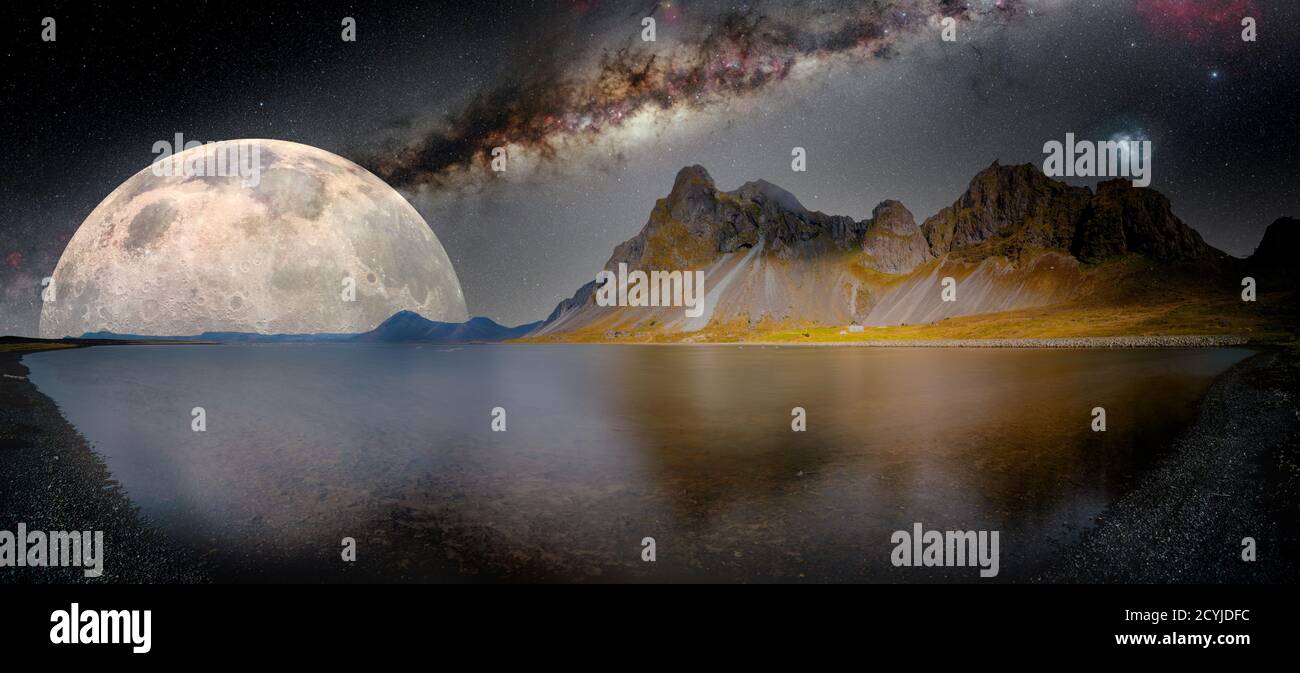 paysage nocturne fantastique avec lac, montagnes et lune. Éléments de cette image fournis par la NASA. Banque D'Images