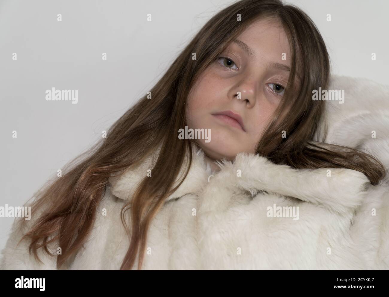 Jeune fille aux cheveux bruns/blonds et aux yeux verts portant un manteau de fourrure Banque D'Images