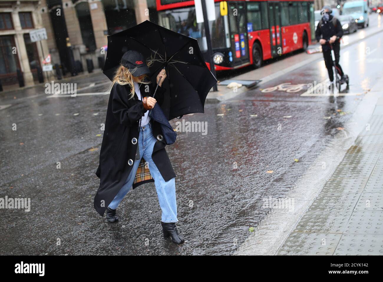Une femme marche à travers la pluie à Westmister, Londres. Certaines parties du Royaume-Uni se préparent à être écrasées par de fortes pluies et des vents violents alors que Storm Alex annonce l'arrivée d'une partie de mauvais temps au cours du week-end. Banque D'Images