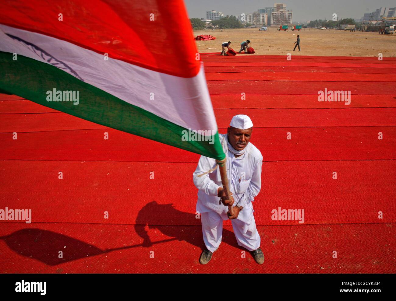Un partisan de l'activiste anti-corruption Anna Hazare fait le drapeau national de l'Inde sur le site du complexe de Bandra-Kurla (BKC) à Mumbai le 26 décembre 2011. Hazare, qui a attisé la colère de l'opinion publique contre les leaders indiens enclins aux scandales cette année, a menacé la semaine dernière de renouveler les protestations à ce qu'il considère comme l'assèchement du projet de loi Lokpal, une mesure qui pourrait faire reculer la campagne électorale du nouvel an du gouvernement. REUTERS/Danish Siddiqui (INDE - Tags: POLITIQUE TROUBLES CIVILS) Banque D'Images