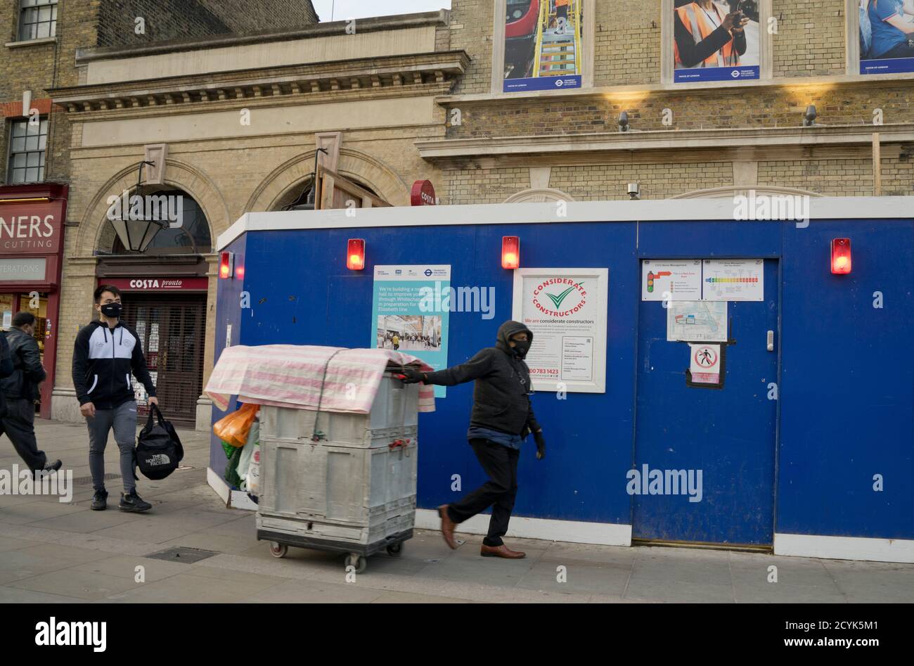 Les résidents du quartier marchent sur le marché de Whitechapel, avec des panneaux indiquant Gardez une distance sociale sécuritaire en raison de la pandémie de coronavirus/Covid-19 À Londres, Engla Banque D'Images