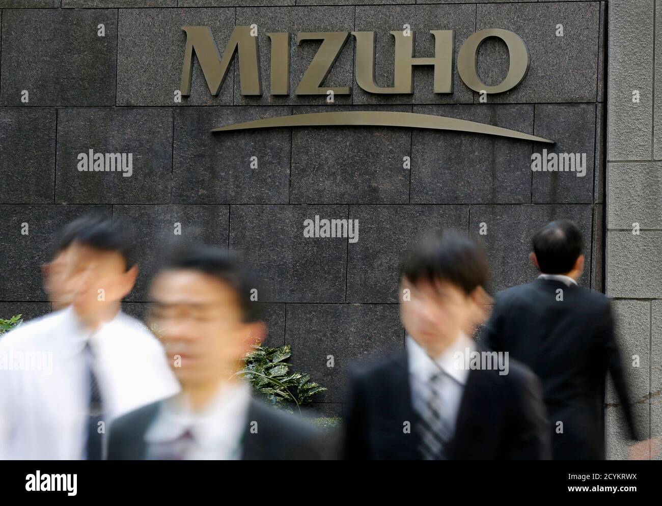 People walk past Mizuho Financial Group's Mizuho Bank headquarters in Tokyo  November 5, 2013. Japan's Financial Services Agency began a probe on  Tuesday into whether all three of the country's big banks
