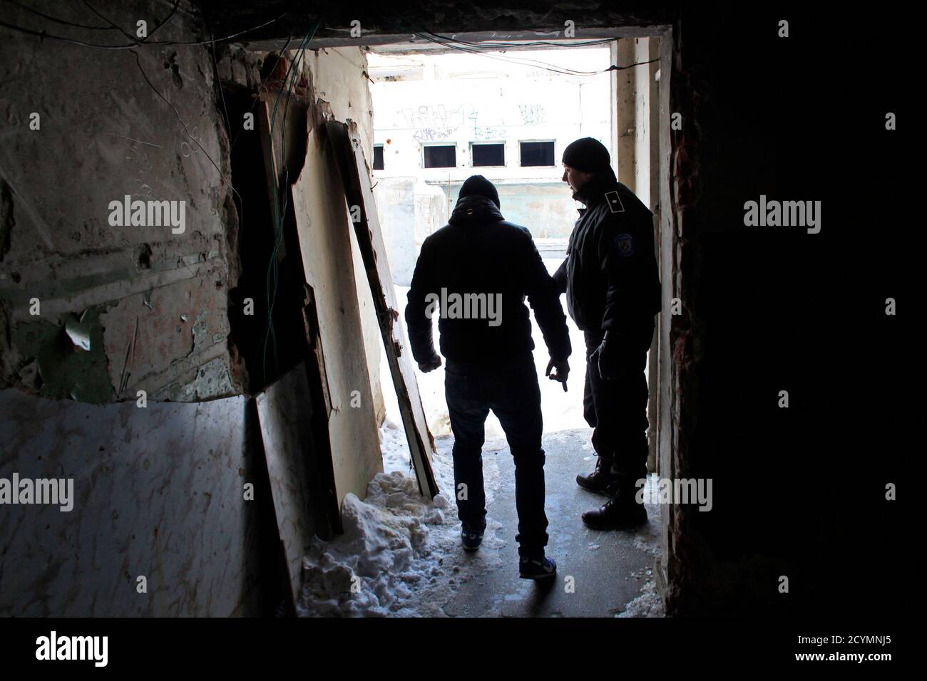 Homeless man Leonard Canagi, 33, (L) discusses with a policeman as he  refuses to go to a community shelter in Bucharest February 1, 2012. Local  police and authorities are trying to relocate