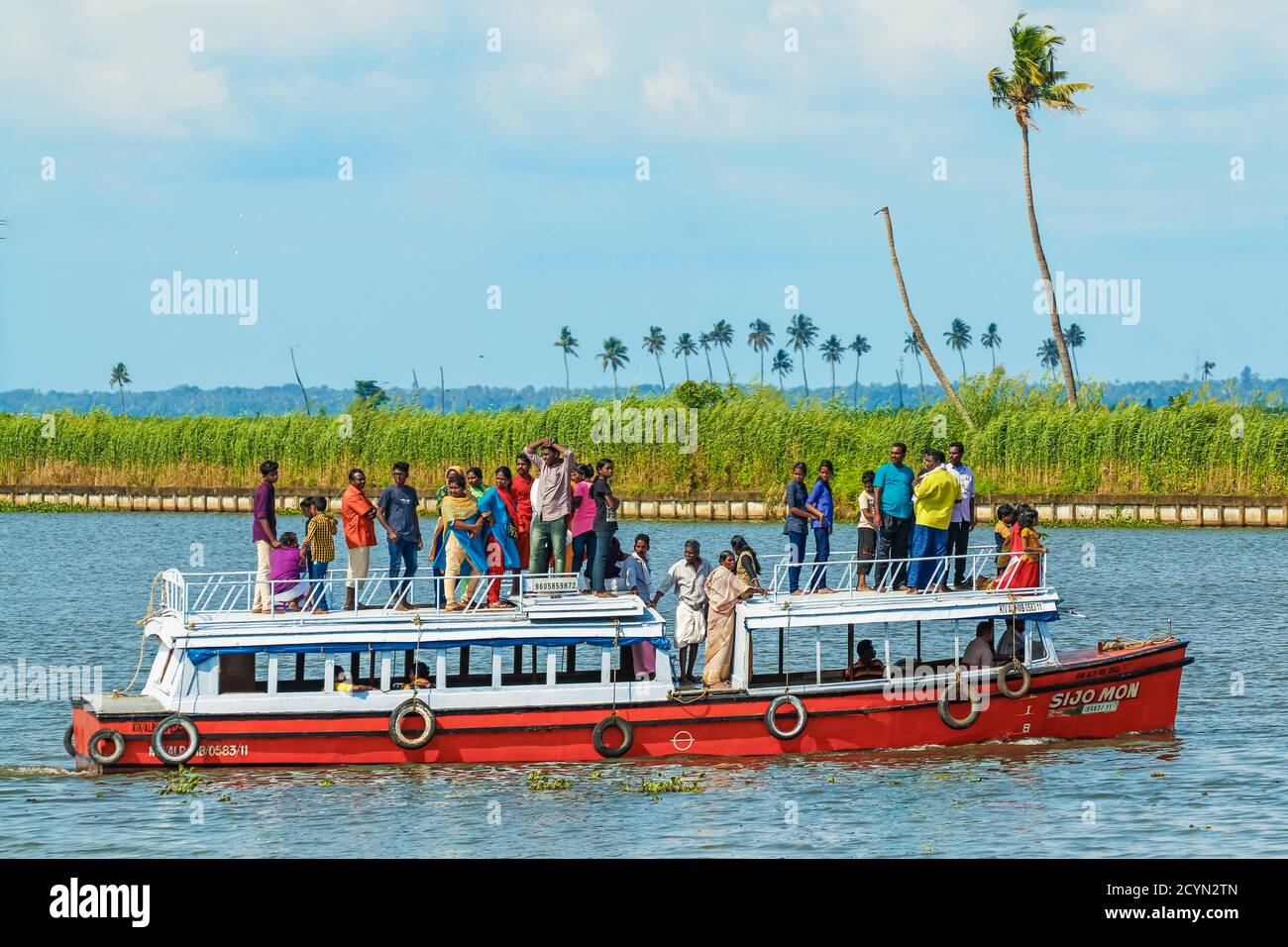 Petit bateau touristique avec des passagers indiens sur le point de visiter une ancienne église lors d'une des croisières populaires dans les eaux de fond; Alappuzha (Alleppey), Kerala, Inde Banque D'Images