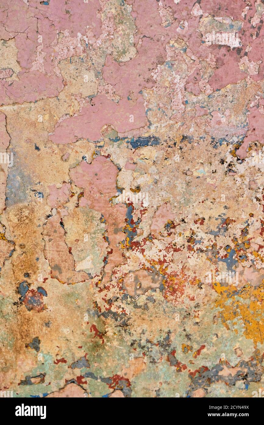 Mur peint et abîmé avec blanc, rouge, bleu où la peinture s'écaille Banque D'Images
