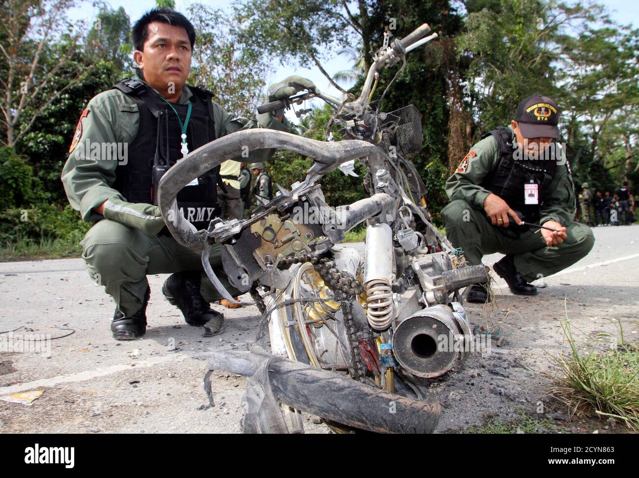 Le personnel de sécurité thaïlandais a effectué une enquête sur le site d'une bombe à moto sur un bord de route dans la province de Pattani, dans le sud de la Thaïlande, au sud de Bangkok, le 12 mars 2012. Deux soldats ont été blessés par une explosion de bombes tout en assurant la sécurité des enseignants dans le district de Sai Buri de Pattani, selon les médias locaux. REUTERS/Surapan Boonthanom (THAÏLANDE - Tags: TROUBLES CIVILS CRIME DROIT POLITIQUE) Banque D'Images