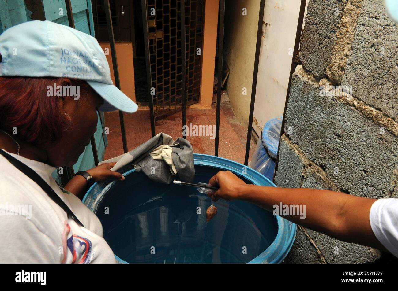 Municipal workers disinfect a tank of water to kill the larvae of mosquitoes  that carry the Chikungunya virus in Santo Domingo, May 23, 2014. The  painful mosquito-borne virus called Chikungunya is spreading