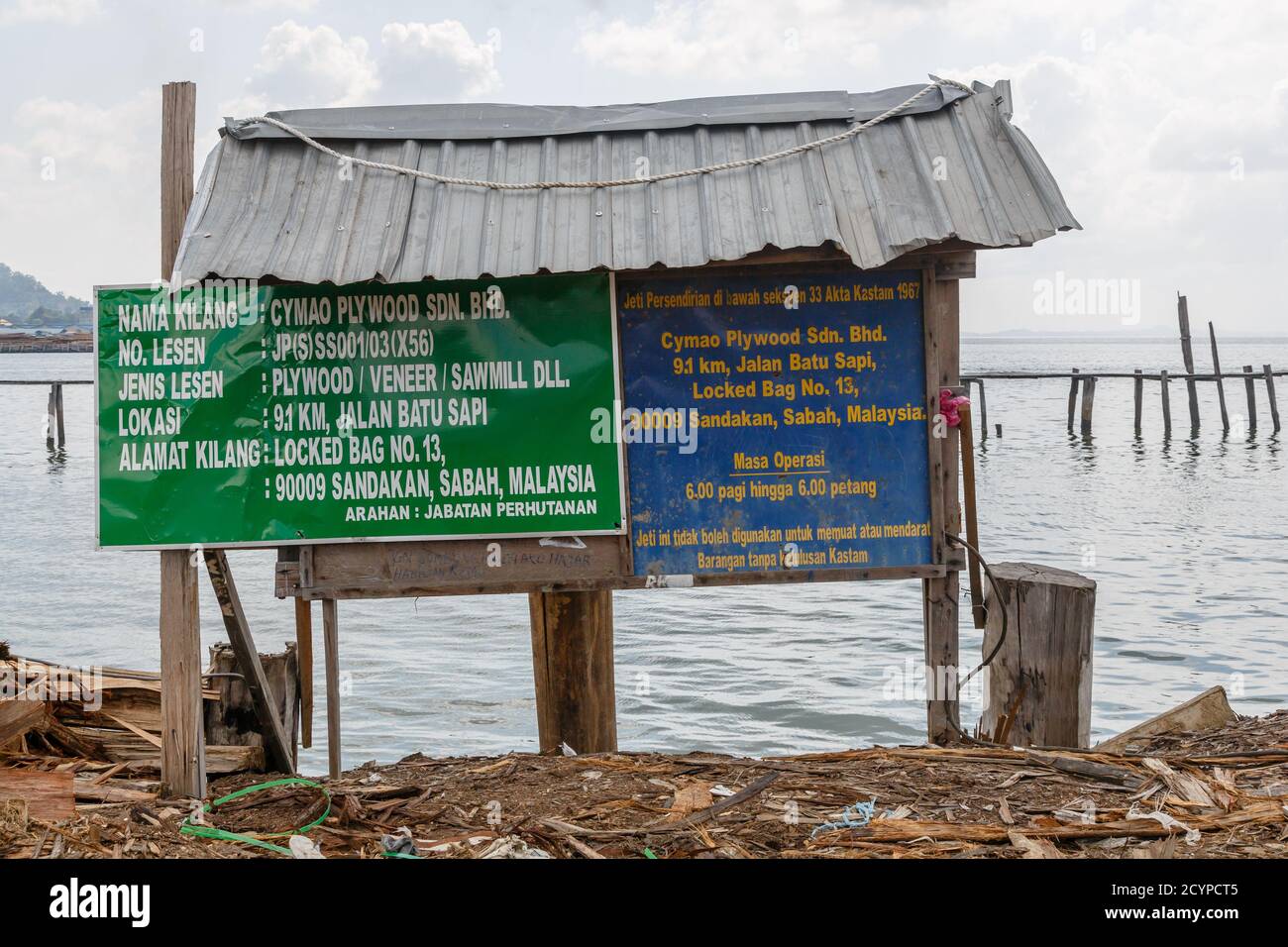 Panneau au point de livraison d'une usine de contreplaqué à Sandakan, Sabah, Malaisie. Les grumes brutes arrivent ici sur une barge pour le déchargement. Banque D'Images